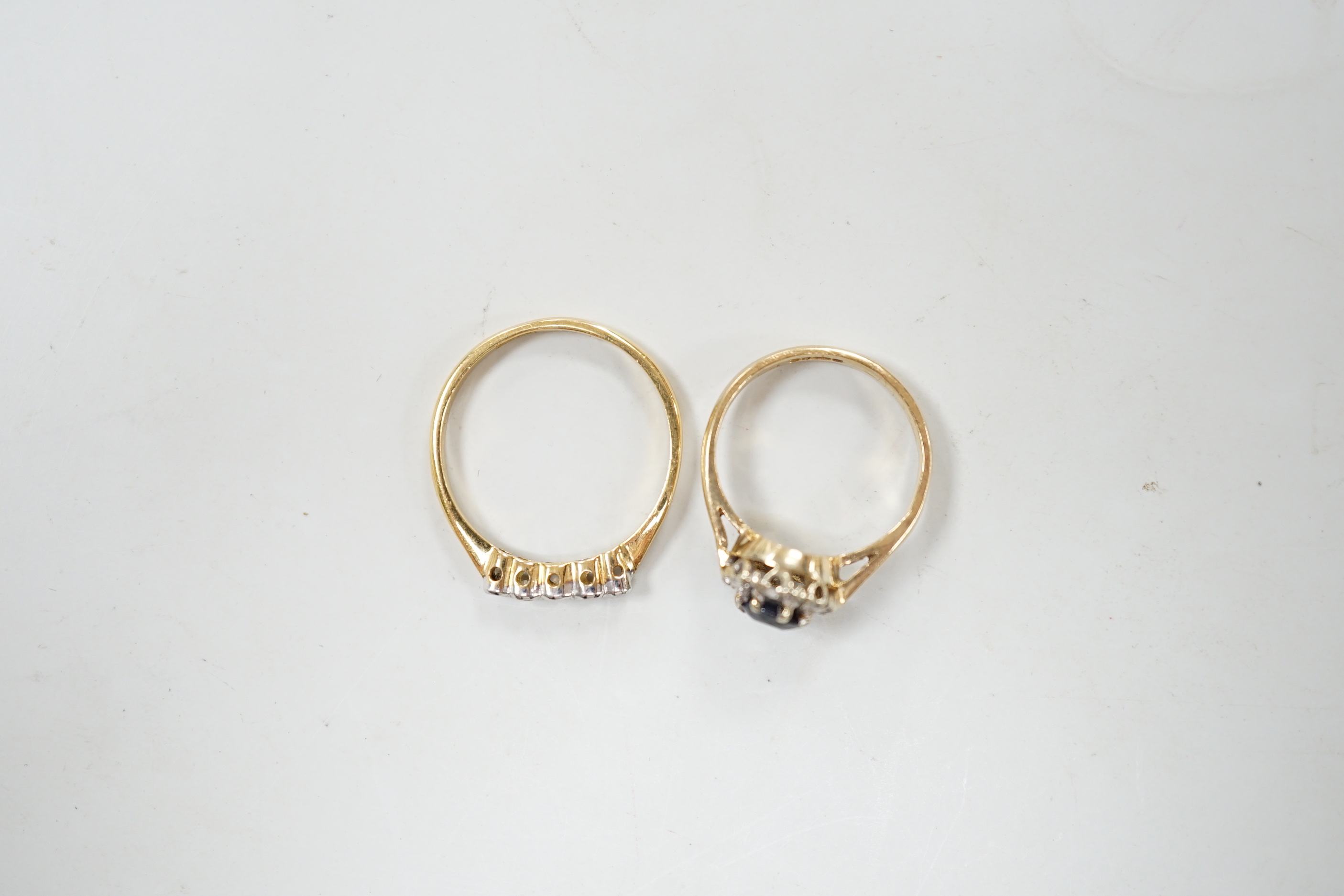 An 18ct and five stone diamond chip set half hoop ring and a modern 9ct gold, sapphire and diamond cluster ring.